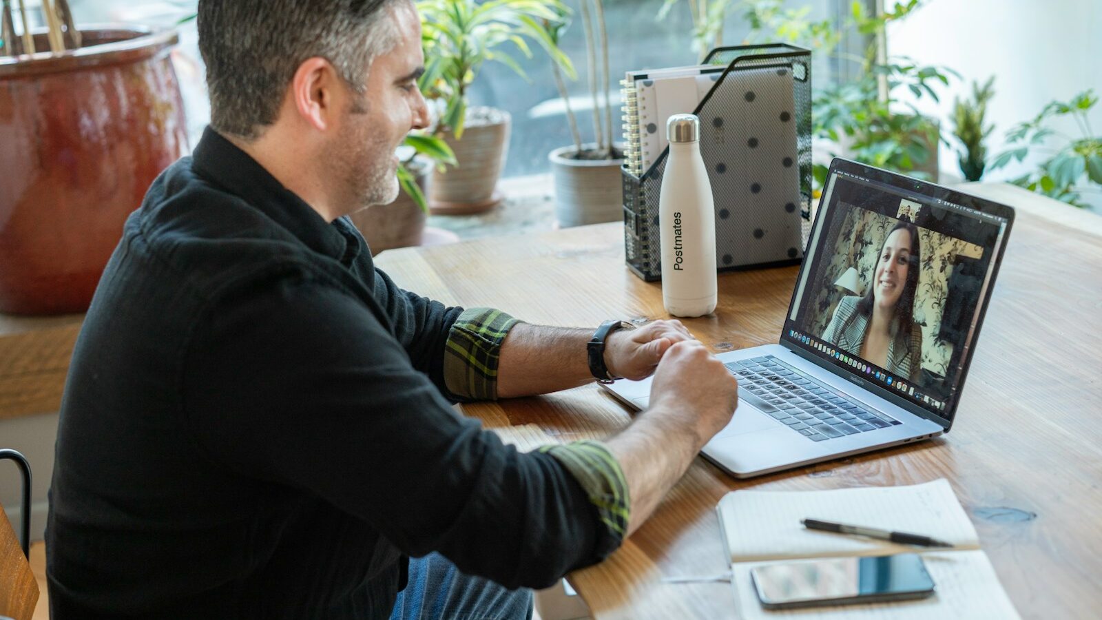 man in black sweater using macbook pro